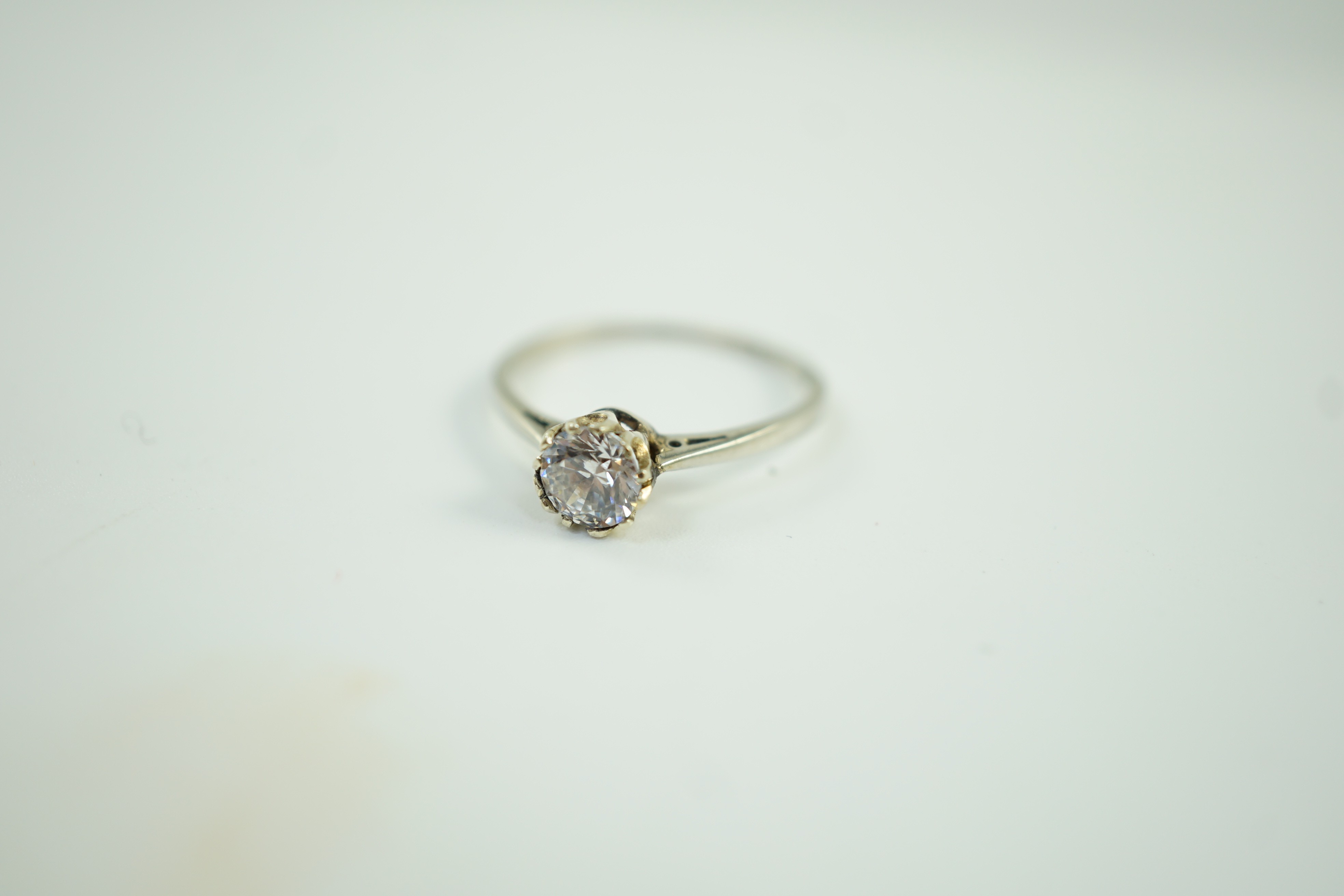 An 18ct and plat set and simulated diamond ring, the stone diameter approx. 4.5mm, size J, gross weight 1.1 grams.